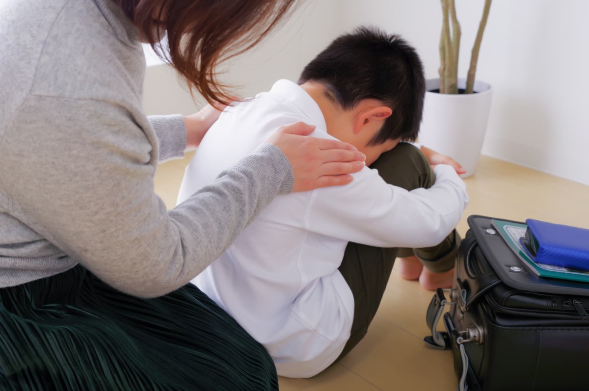 悪い歯並びがコンプレックスで落ち込む子どもと慰める母親
